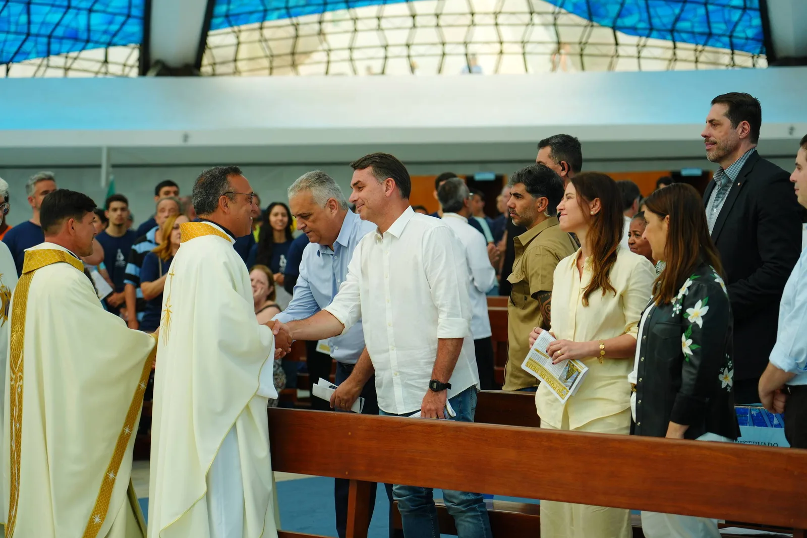 Flávio Bolsonaro e Lula fazem gestos a católicos no Dia de Nossa Senhora